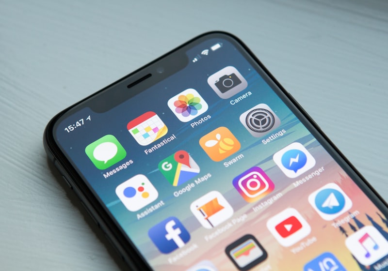 A smartphone held in hand, showing a grid of application icons.