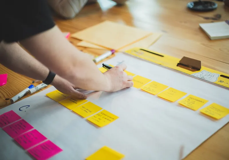 Hands arranging colourful notes in a creative brand-strategy session.